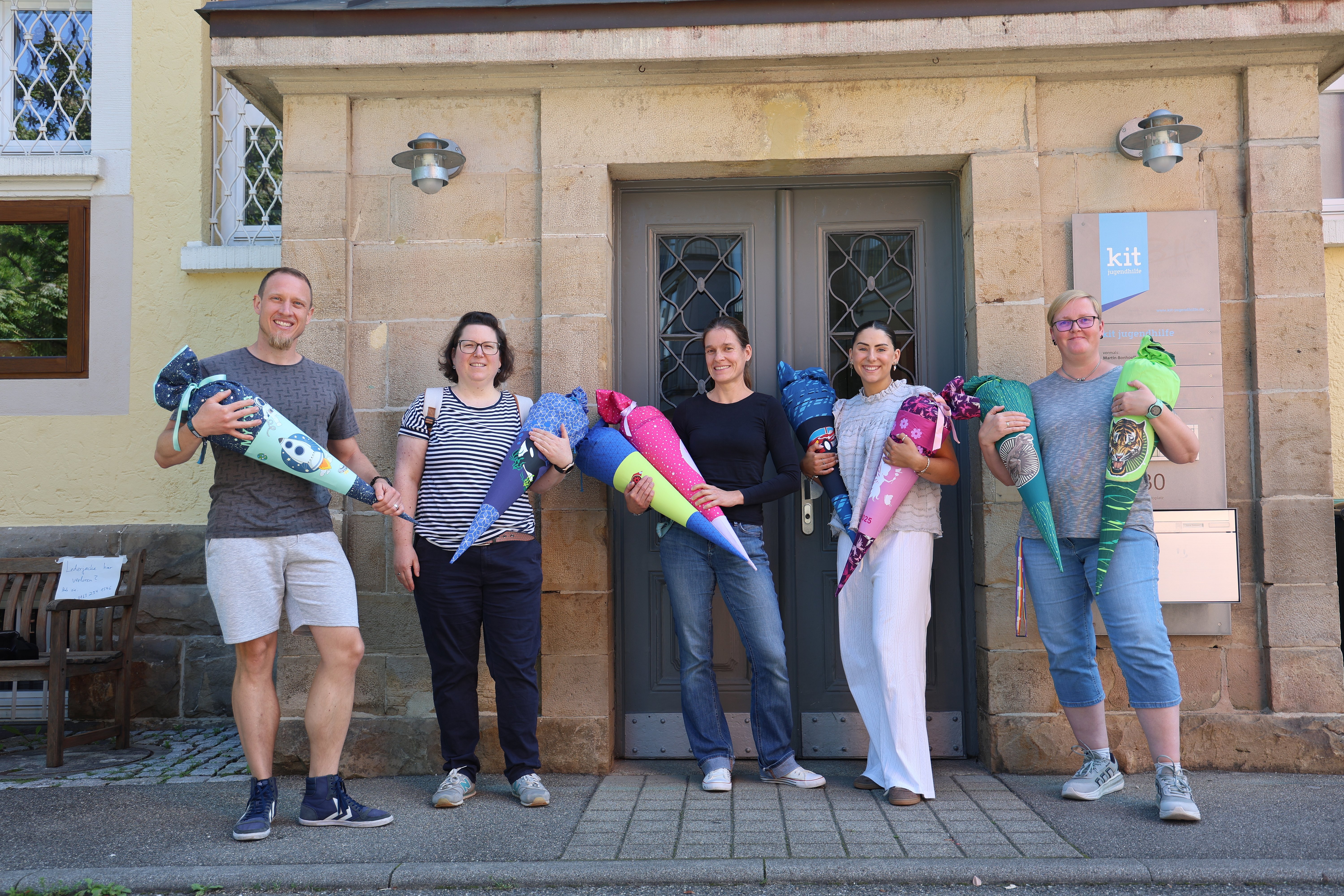 kit Mitarbeiter und Mitarbeiterinnen mit bunten Schultüten