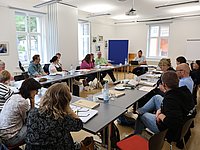 Teilnehmende während der Fortbildung an Tischen sitzend